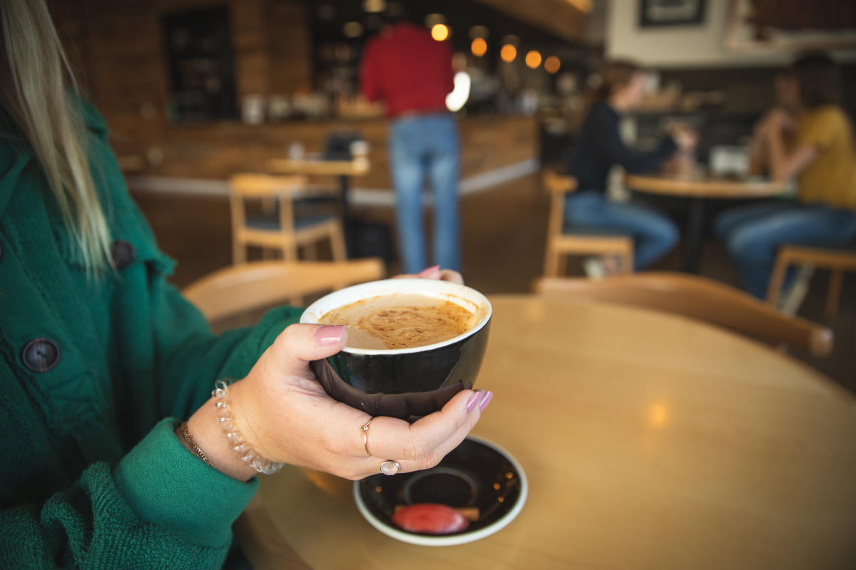 A girl drinking coffee at ECDC in downtown Eau Claire