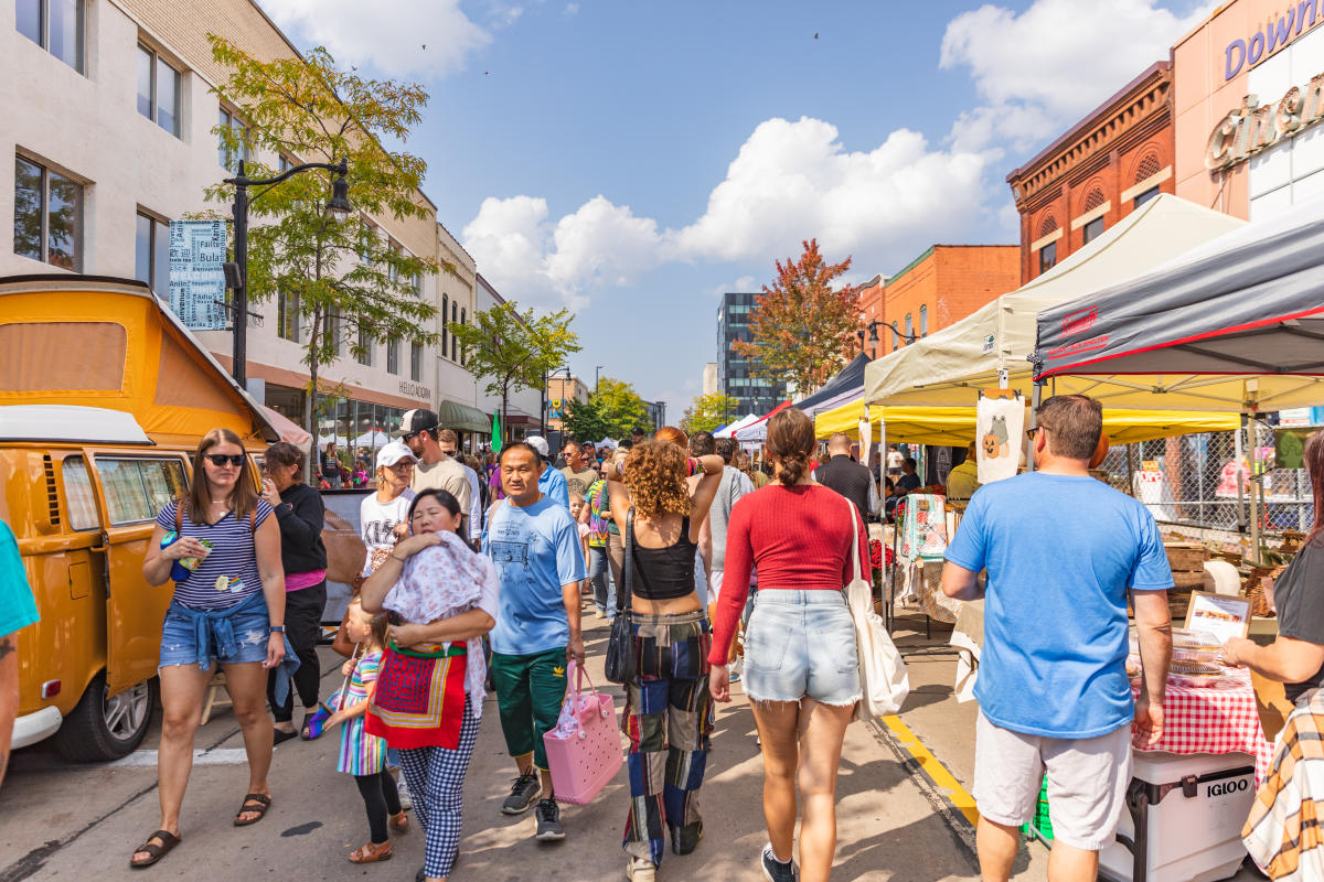 A crowd of people walking through vendors at the Fall Festival in downtown Eau Claire