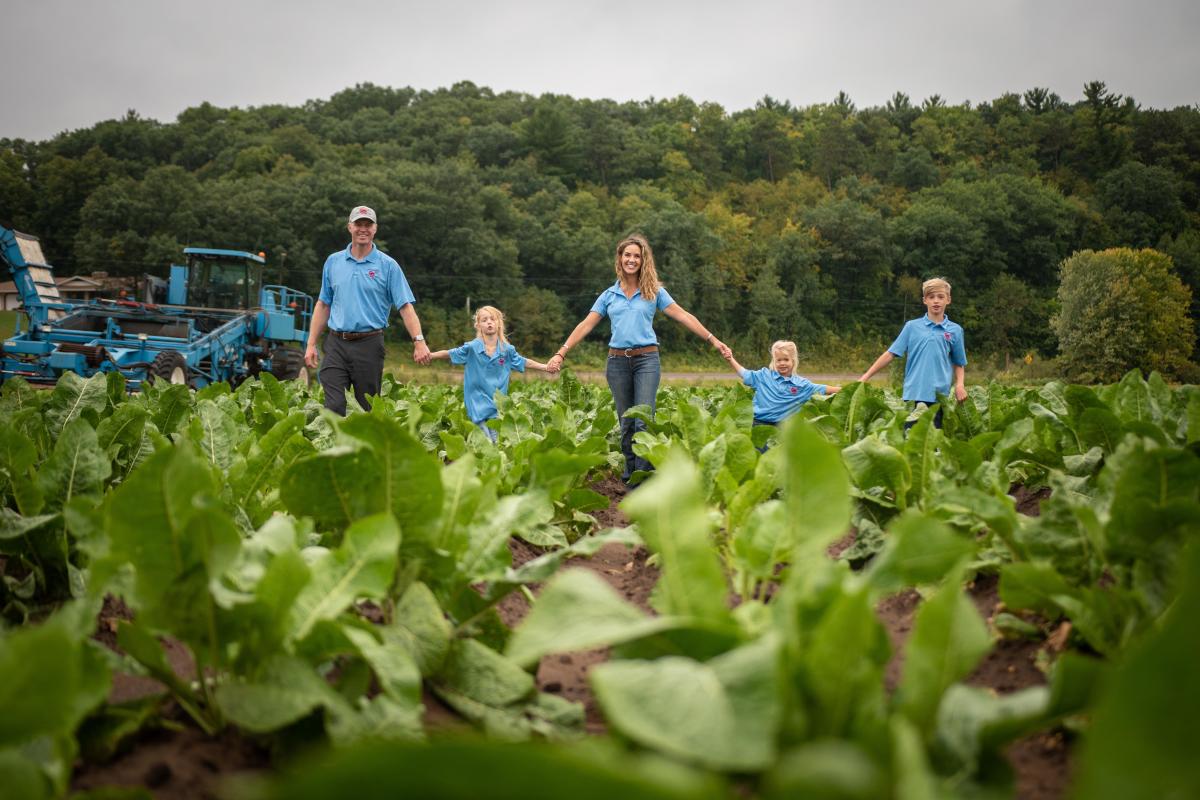 Rygg Family holding hands in a horseradish crop on Huntsinger Farms