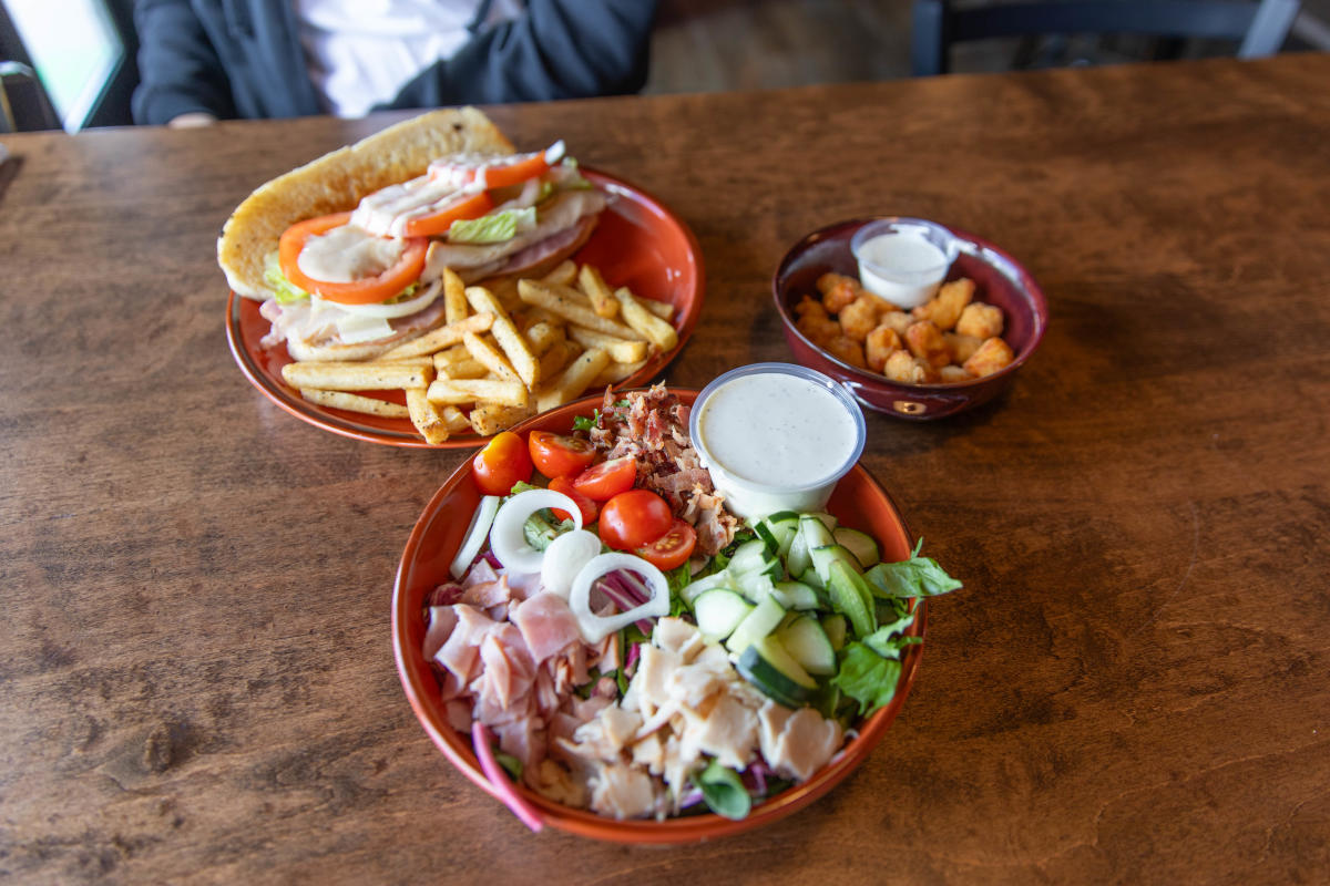A salad, sandwich & Fries, and order of cheese curds at Fella's Loaded Goat