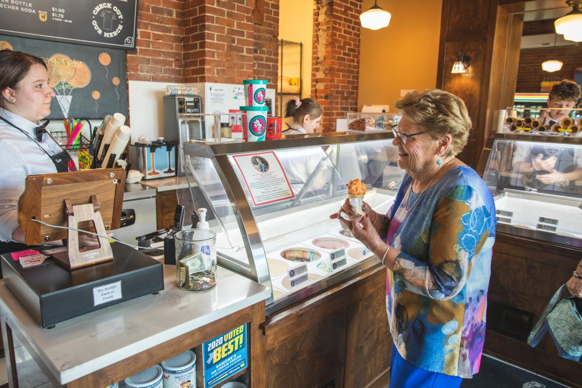 A woman paying for her ice cream cone at Ramone's Ice Cream Parlor in downtown Eau Claire