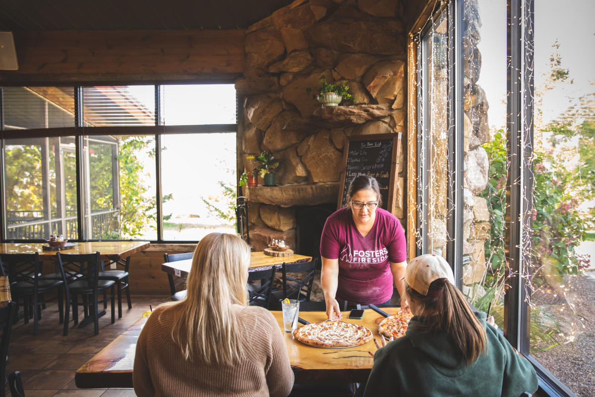 Pizza being served at a table of two at Foster's Fireside