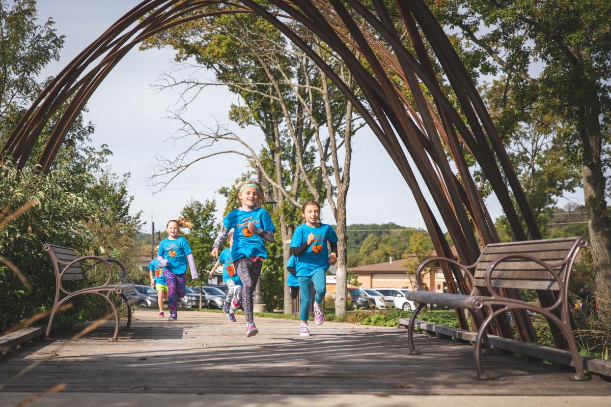 Young girls running in the Ginormous Pumpkin Festival youth race at River Prairie