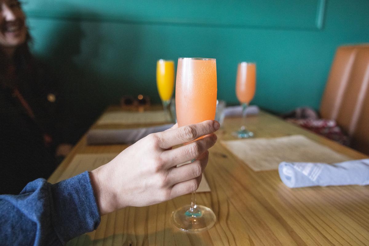 A person holding a mimosa at The Good Wives