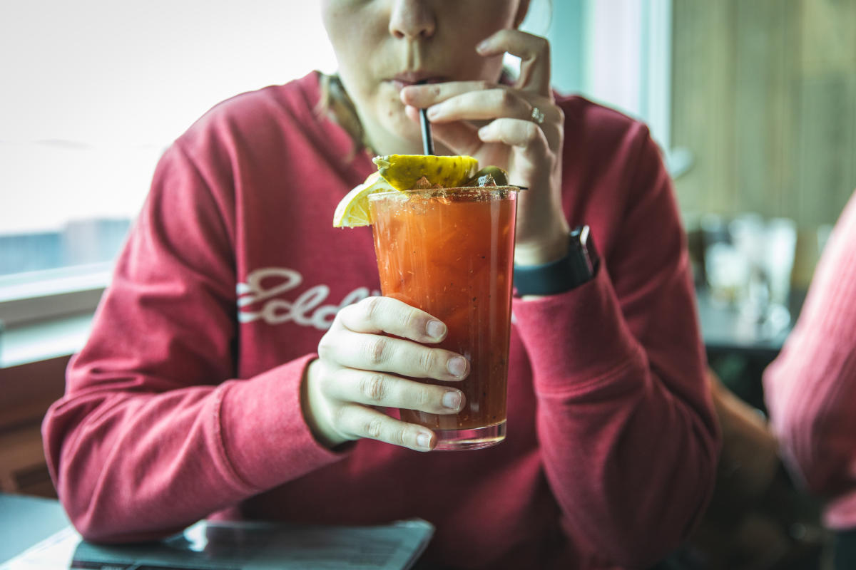 A girl sipping a Bloody Mary at Hangar 54