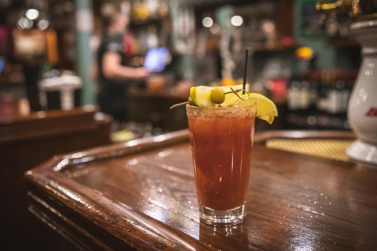 A Bloody Mary in a glass served with a salted rim, pickle, olive at lemon at Houligans Steak & Seafood Pub