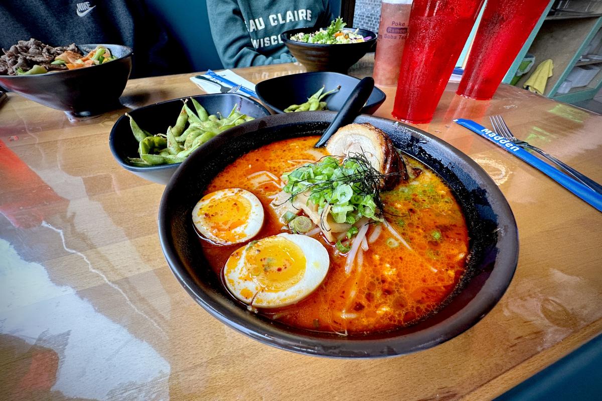A bowl of ramen with eggs, pork, noodles, and garnishes at Madden Ramen