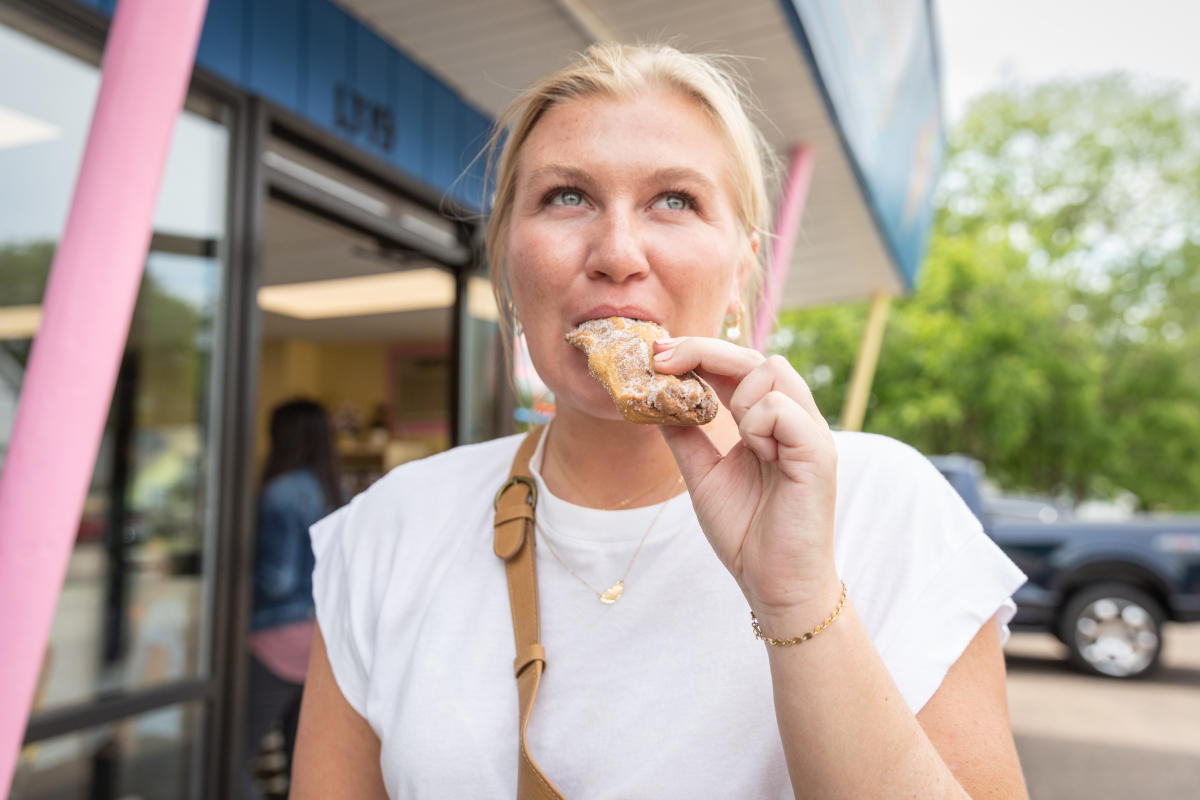 A girl eating a sugary donut at The Ice Cream & Bakery Shop
