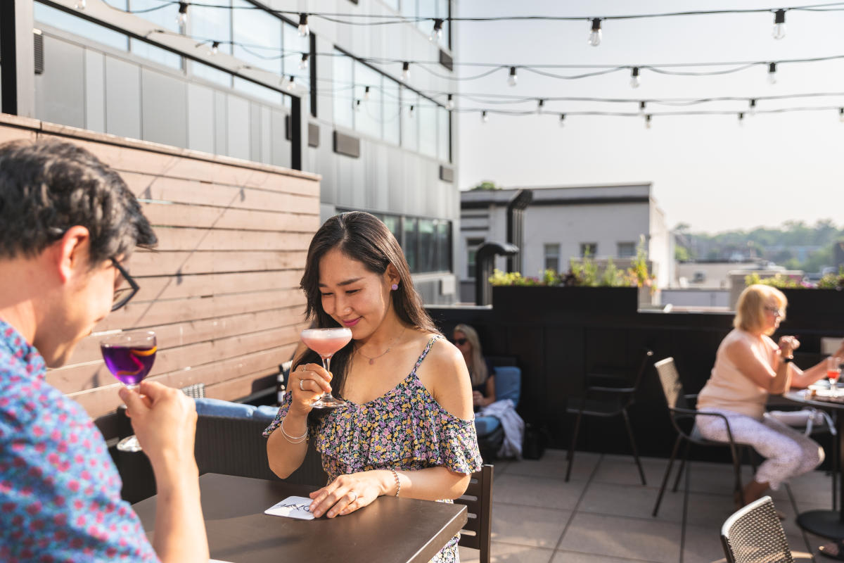 A man and woman having cocktails on the patio at Dive