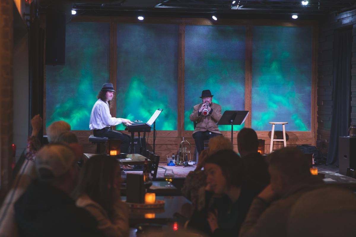 A jazz duo playing keyboard and trumpet on stage at the Lakely at the Oxbow Hotel in Eau Claire, WI