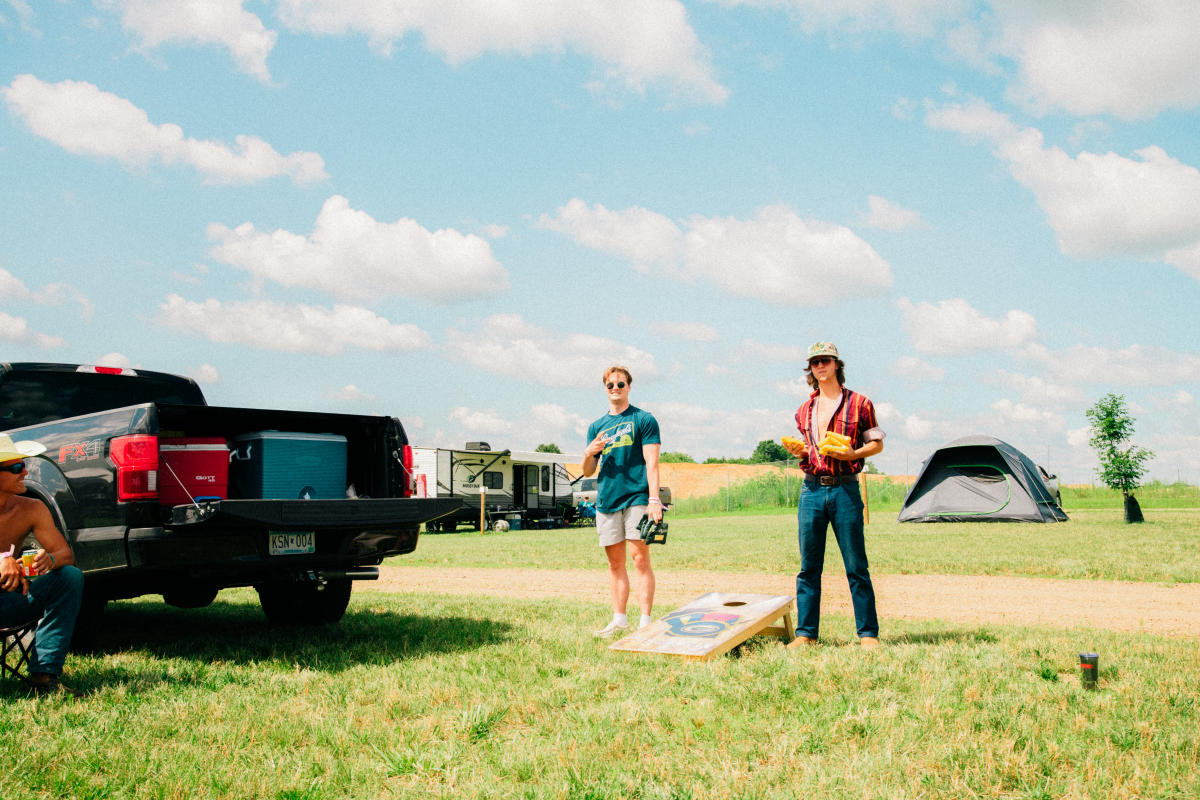 Two guys playing beanbags at the festival grounds campsite