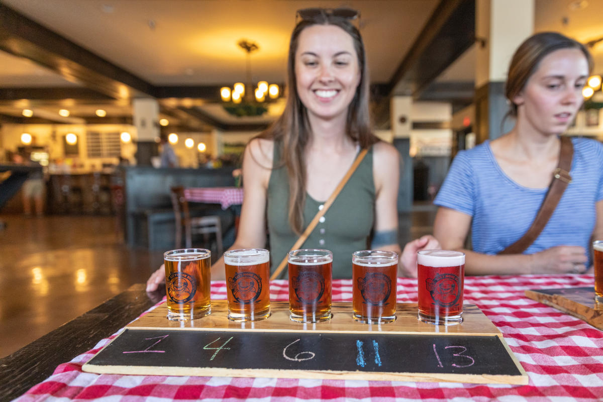 Two girls enjoying flights of beer at Lazy Monk Brewing in downtown Eau Claire