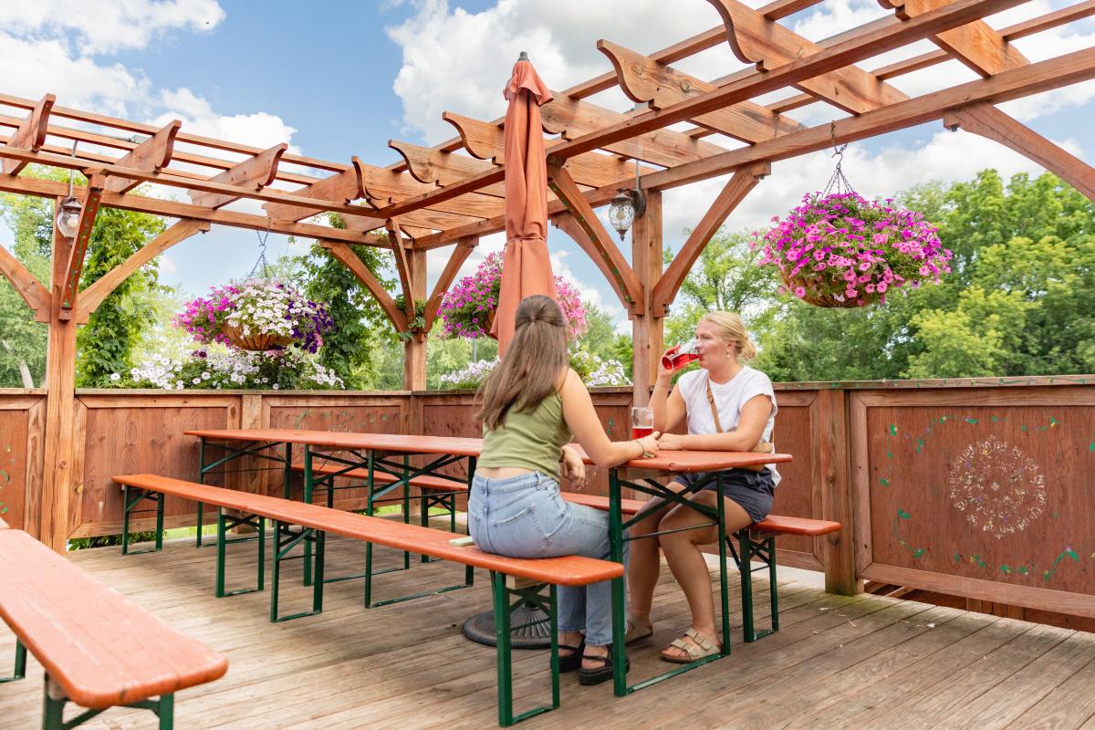 Two women enjoying beer at the beer garden at Lazy Monk Brewing in downtown Eau Claire
