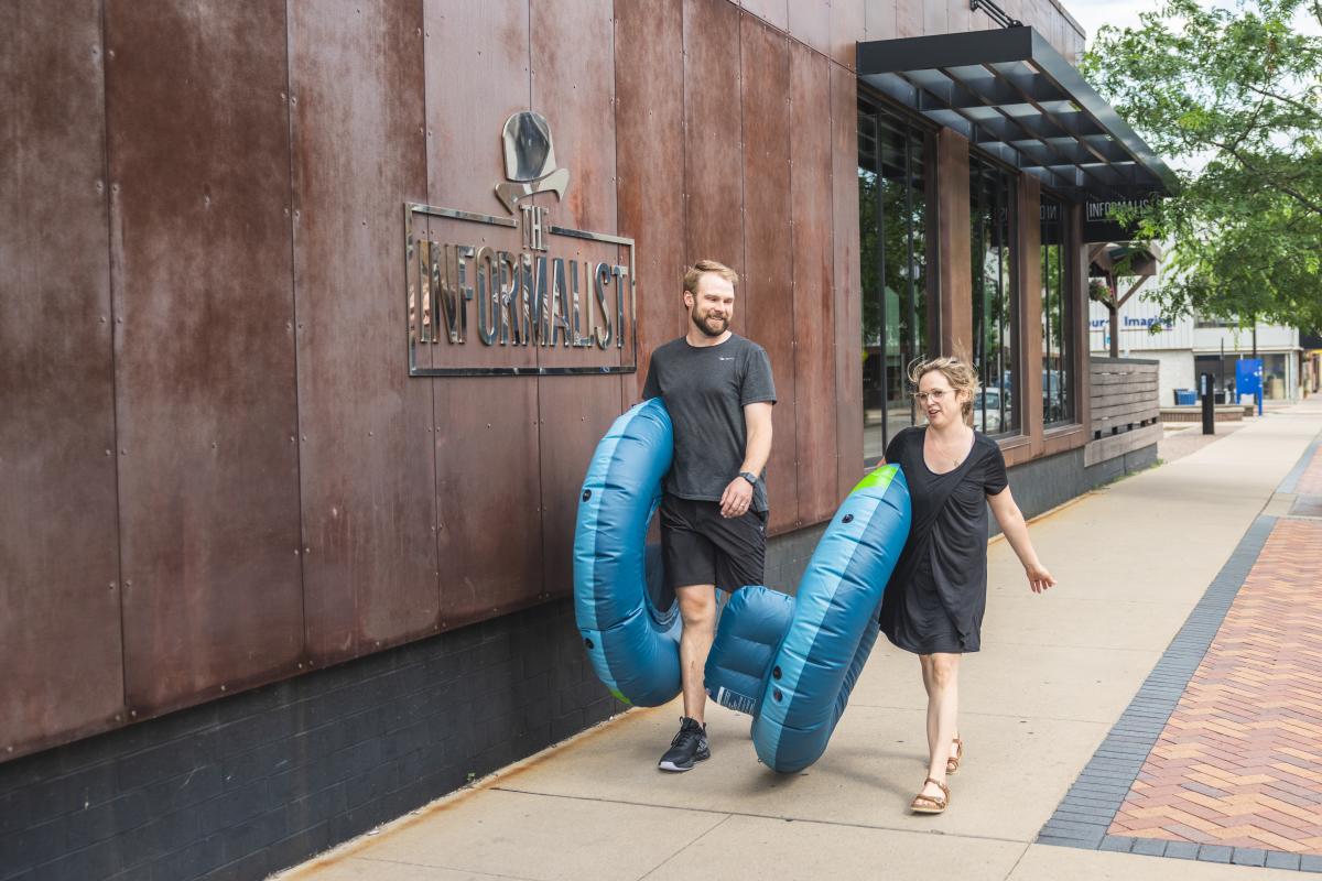 A couple carrying their river tubes outside The Informalist at The Lismore Hotel
