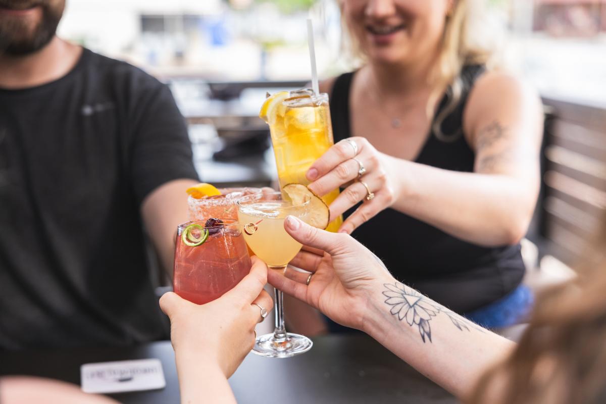 4 cocktails clinking glasses together at The Informalist