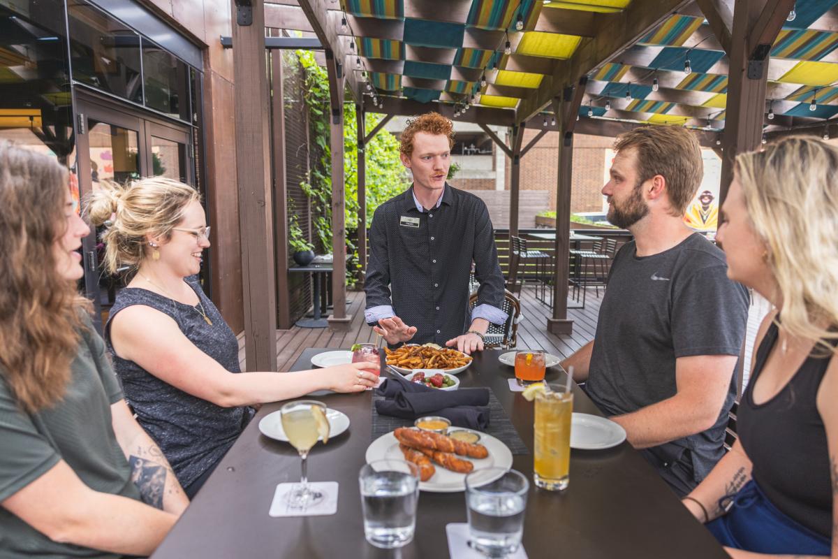 A group of friends getting their food on the patio at The Informalist
