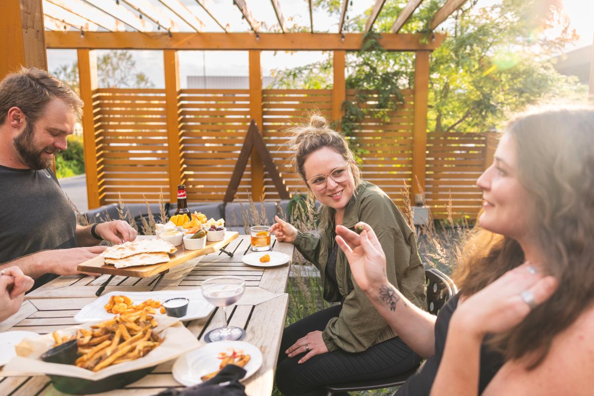 A group of friends dining outside at The Lakely