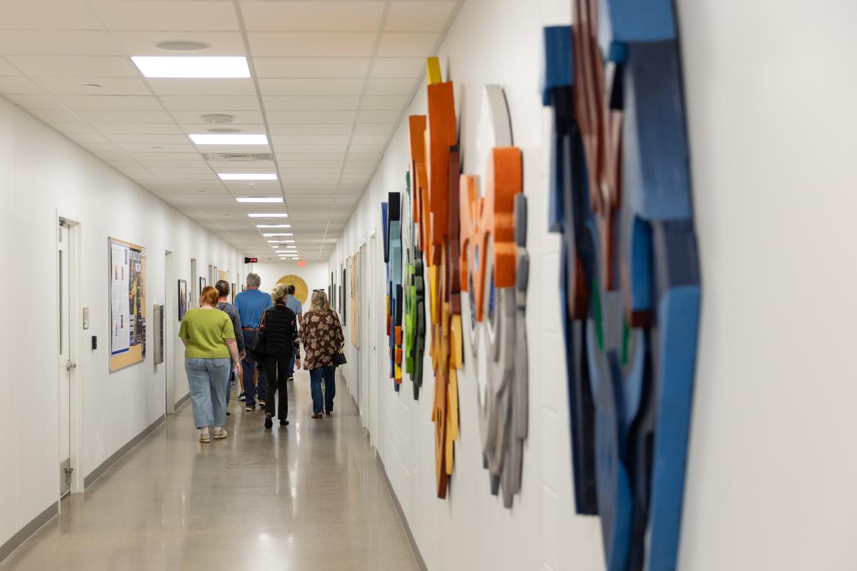 A group walking through the halls of the Pablo Center seeing the art