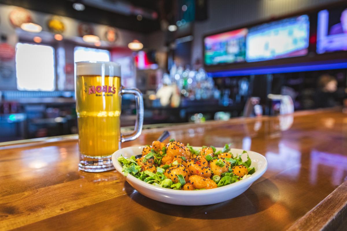 A beer and dish of food at Monk's Bar + Grill