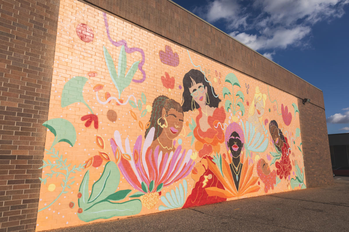An orange, pink, and colorful mural in downtown Eau Claire