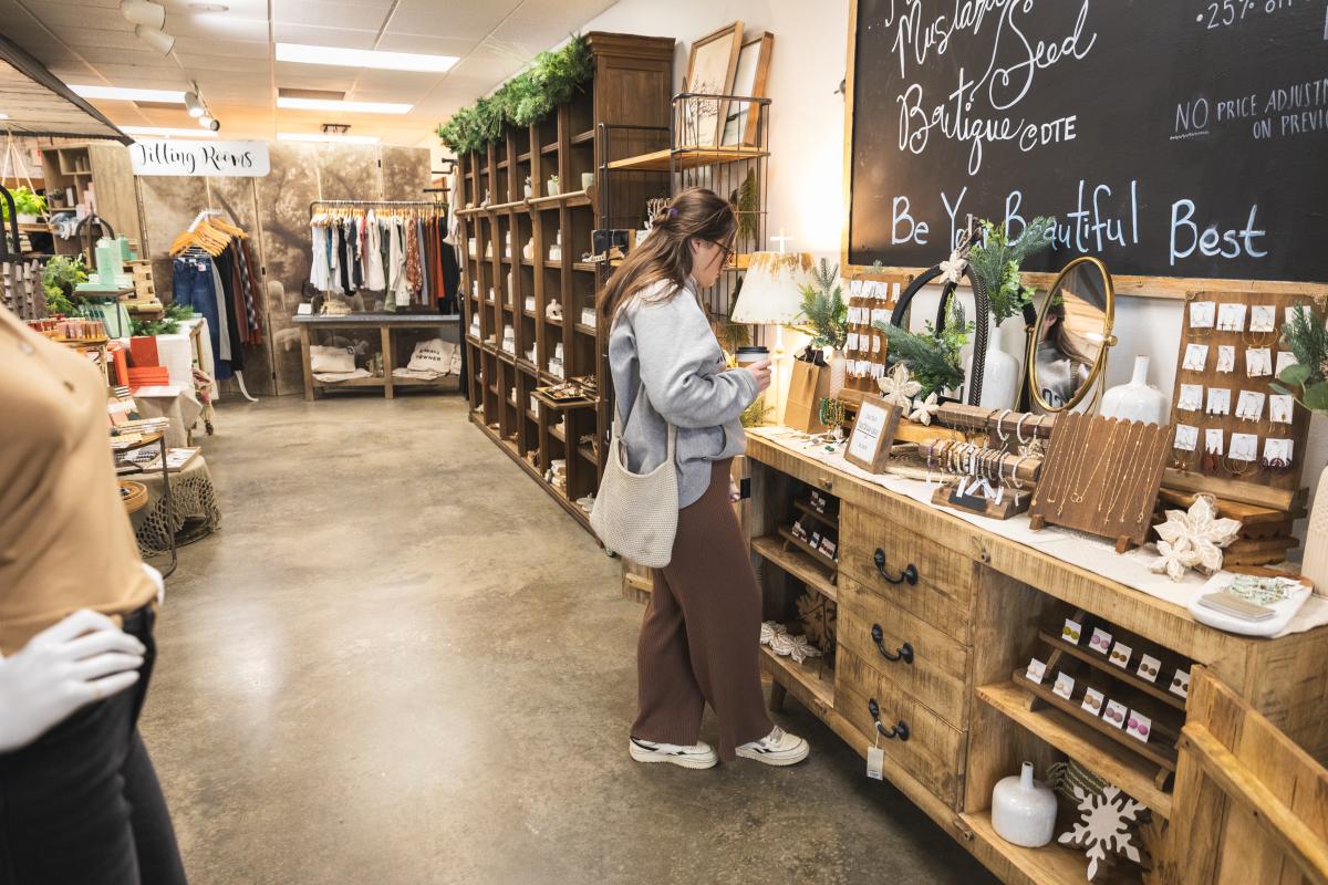 A girl browsing though jewelry at the Mustard Seed Boutique
