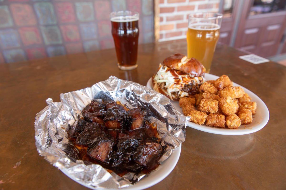 A few plates of BBQ meat, tots, a sandwich, and beers