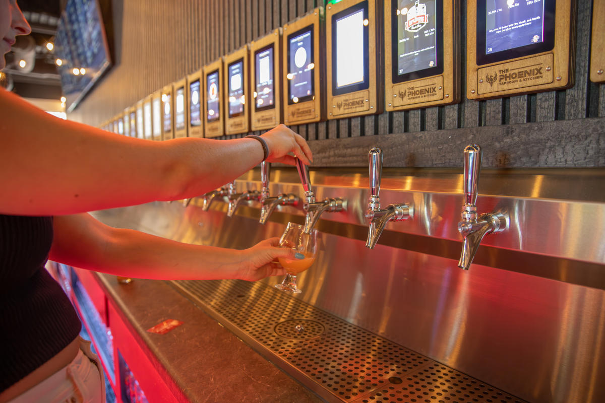 A girl pouring herself a glass of beer at the Phoenix Taproom & Kitchen