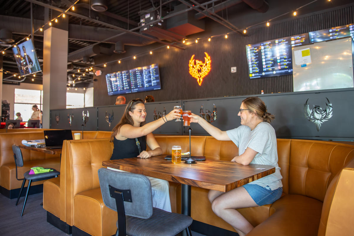 Two girls clinking their glasses together at The Phoenix Taproom