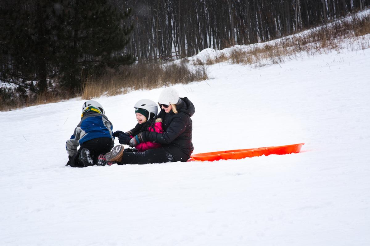 Kids sledding down a hill at Pinehurst Park