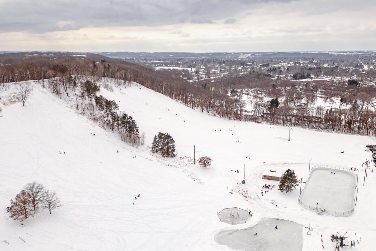 A drone shot of people sledding at Pinehurst Park