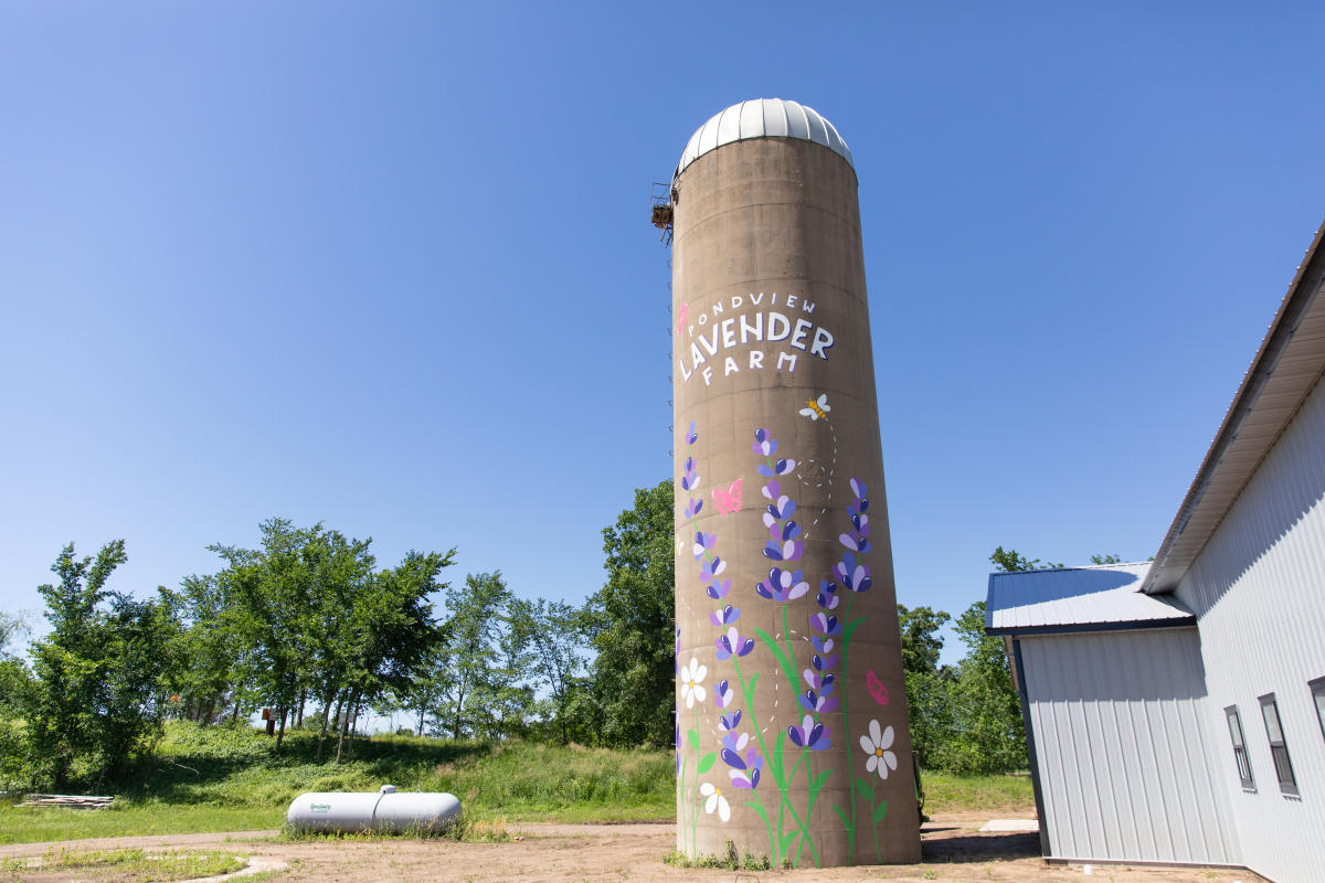 A silo with a lavender mural painted on the side