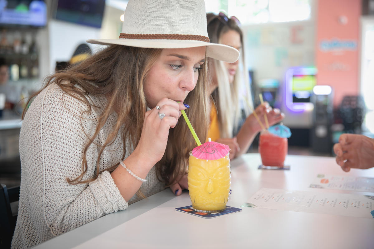 A girl sipping a frozen margarita out of a tiki glass at The Island Parkside