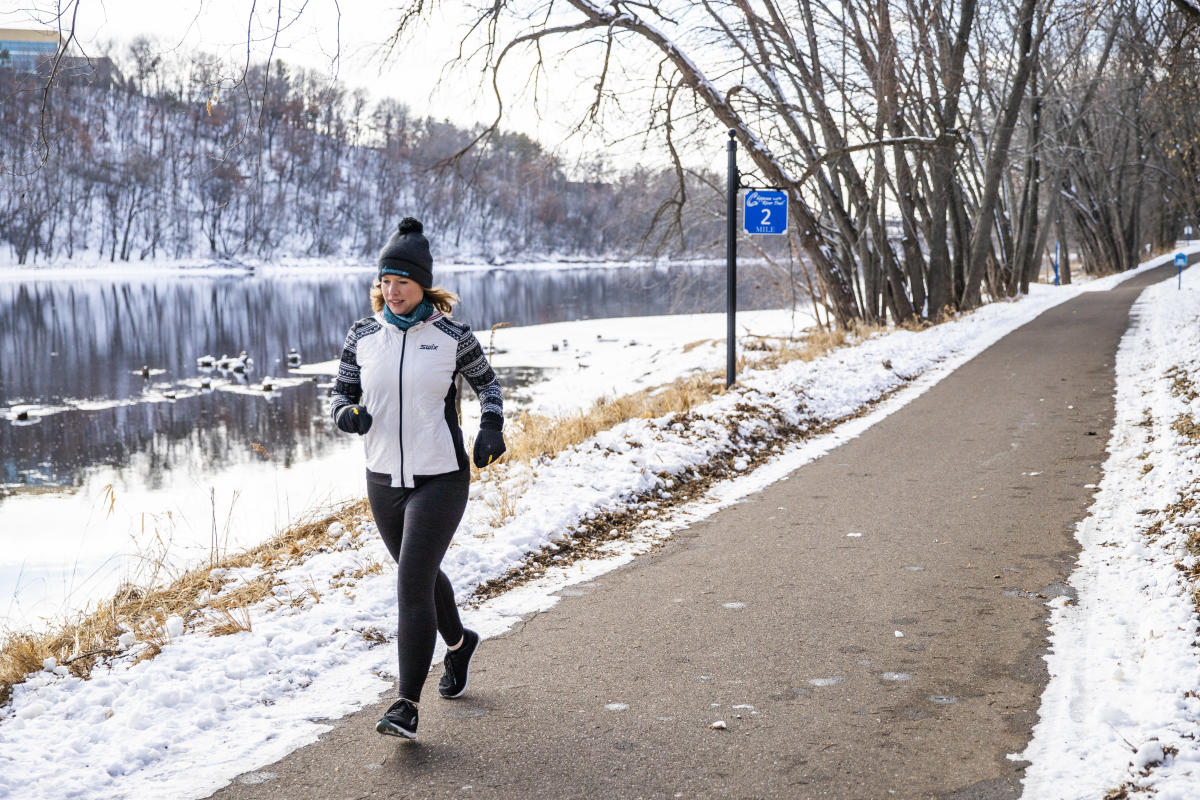 A woman running on the winter recreation path along the Chippewa River in the winter