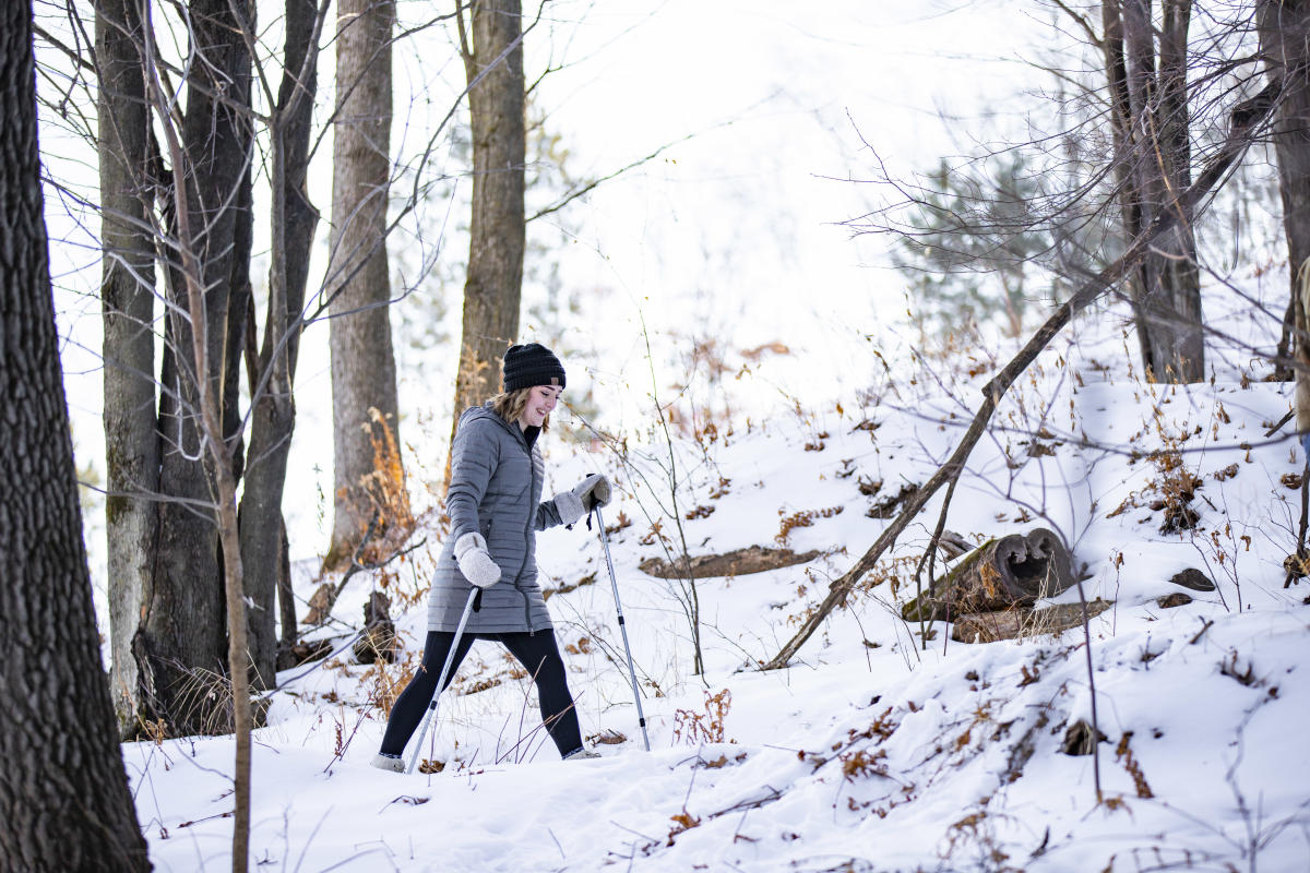 A girl snowshoeing at Pinehurst Park in winter gear