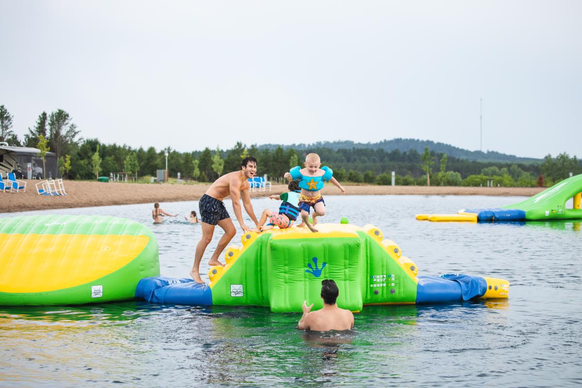 Boys playing on a "wibit" inflatable on the lake at Stoney Creek Resort in Osseo, WI
