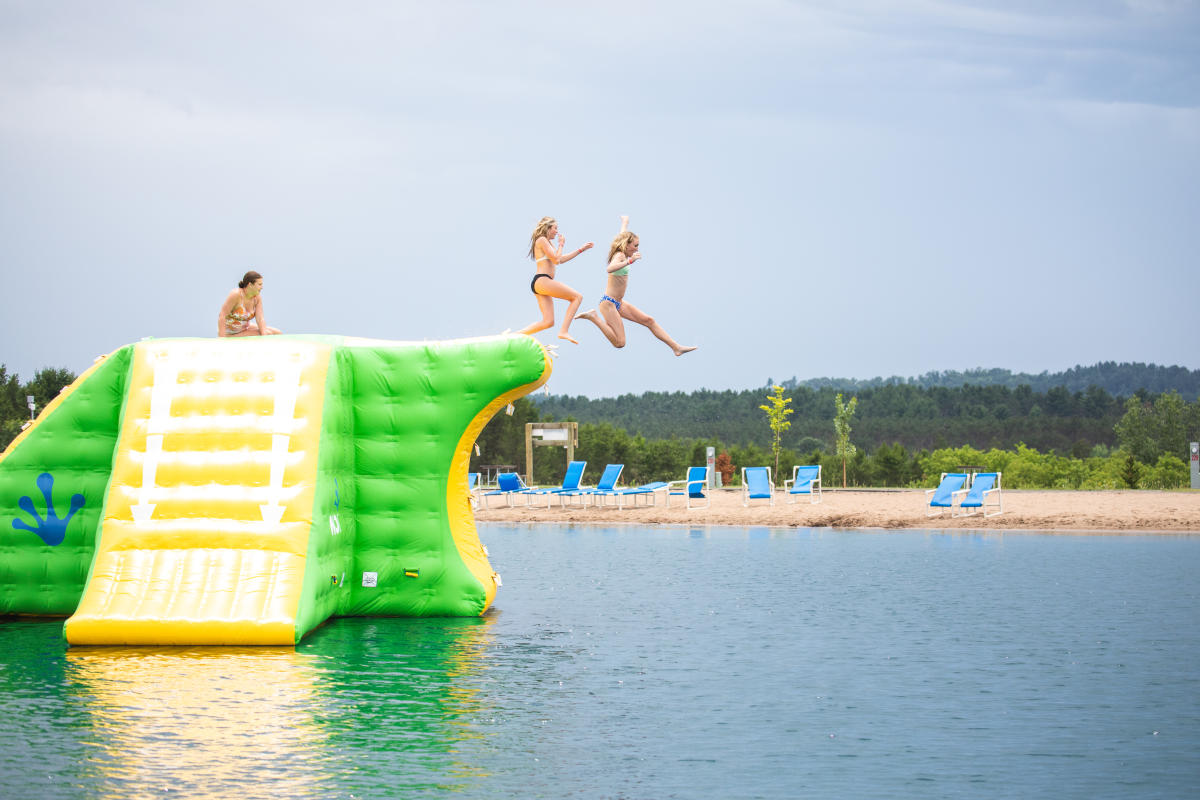 Two girls jumping off the Wibit at Stoney Creek