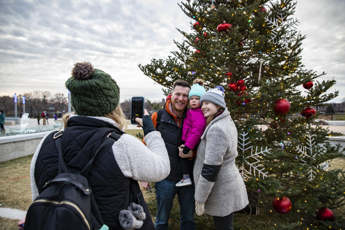 A family taking a photo in front of a Christmas tree in Haymarket Plaza