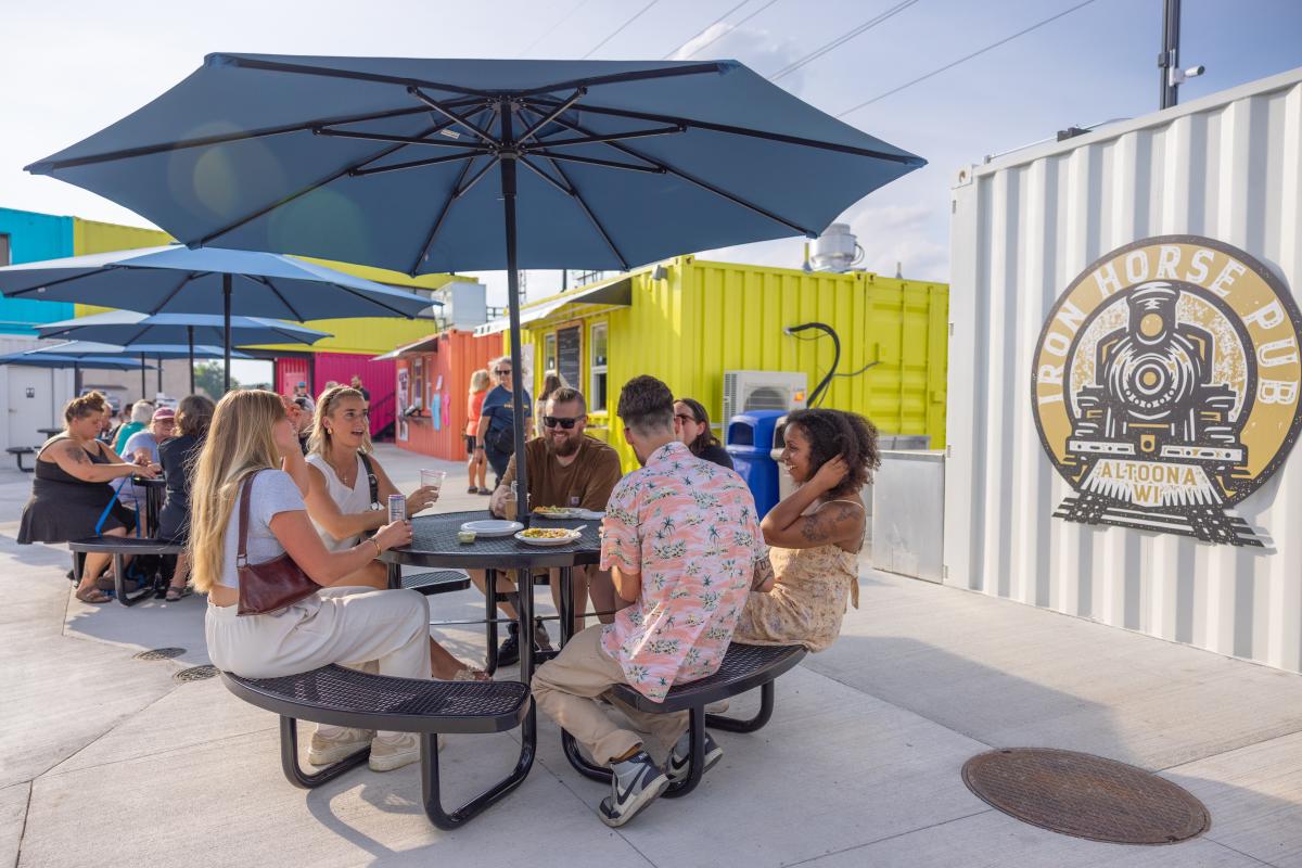 A group sitting at a table and chatting at The Yard Container Park