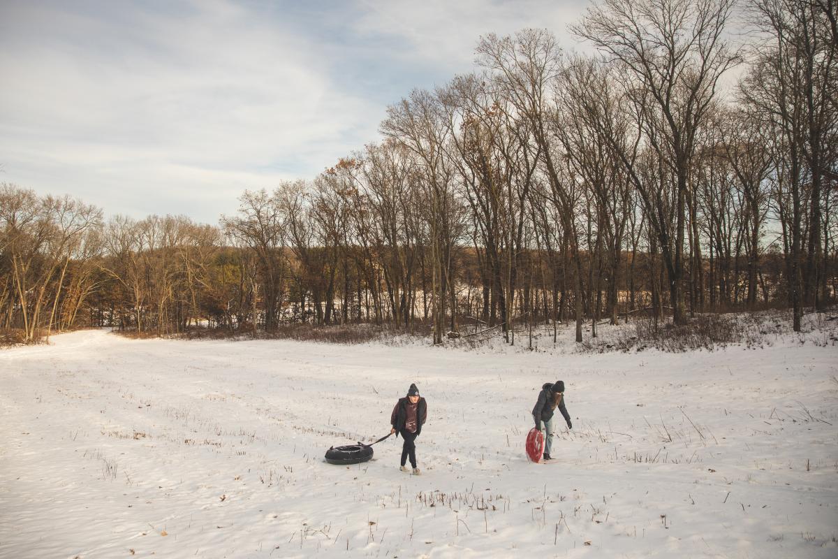 2 Young adults sledding at the hill in Wheaton Park