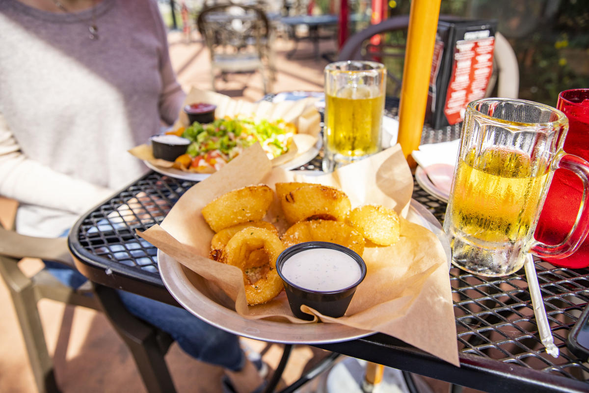 Onion rings, nachos, and beer served on the patio at Wisco's
