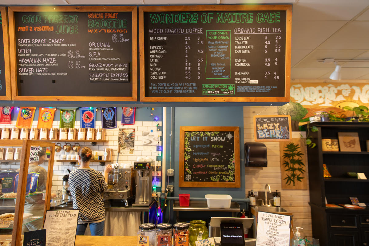 A barista making a drink behind the counter at Wonders of Nature Cafe