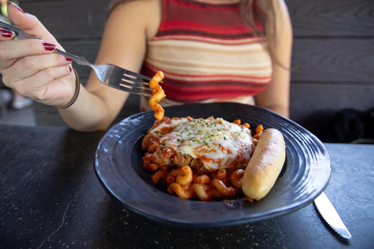 A girl eating a bowl of pasta at Cowboy Jack's