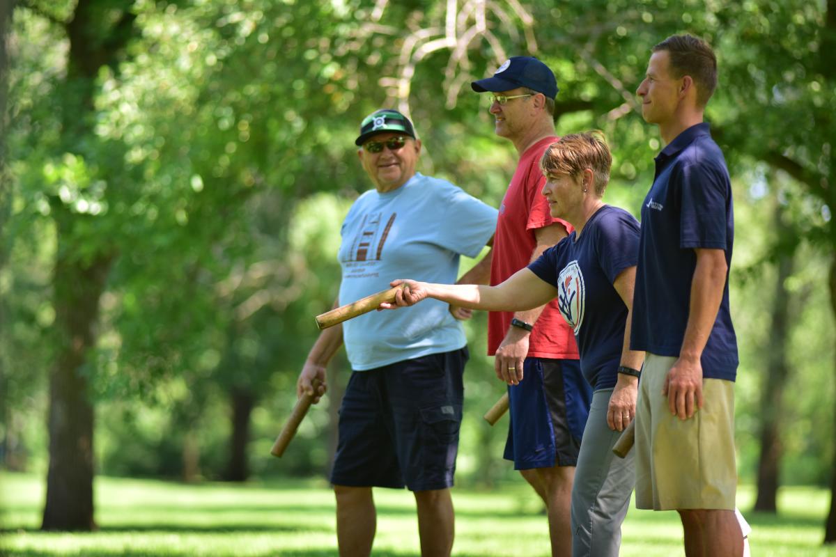 A group of 4 playing Kubb in the park