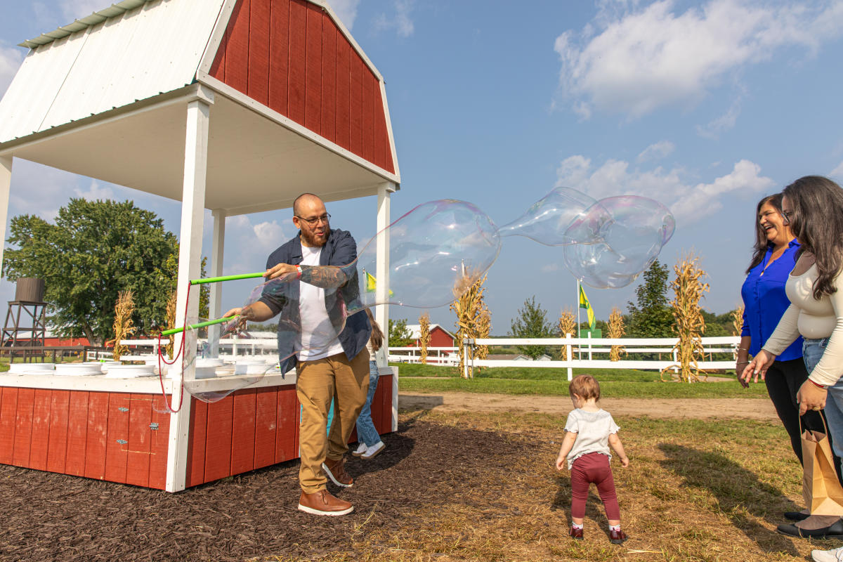 A dad creating a huge bubble at the bubble bar at Ferguson's Orchards