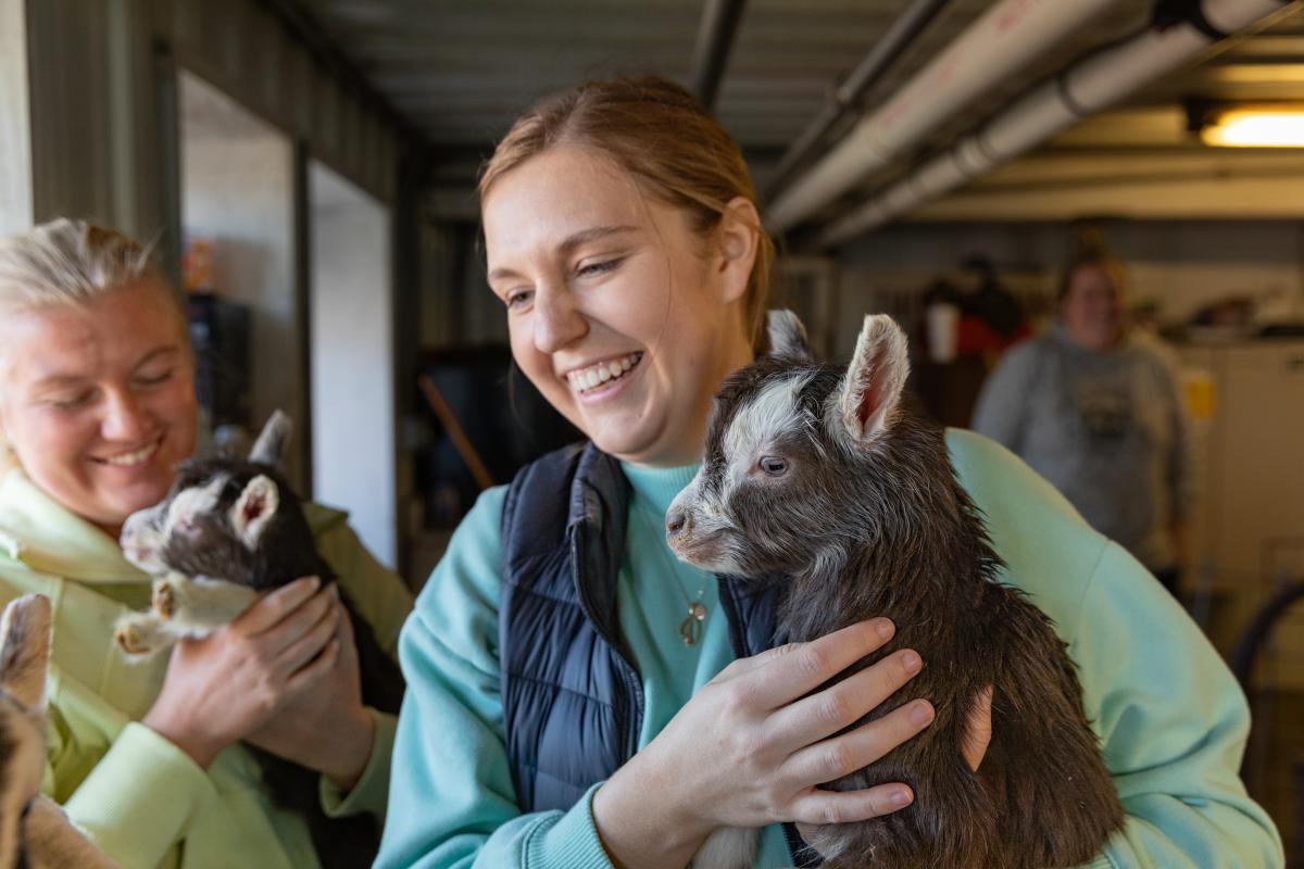Two girls holding baby goats at Lymett Farms