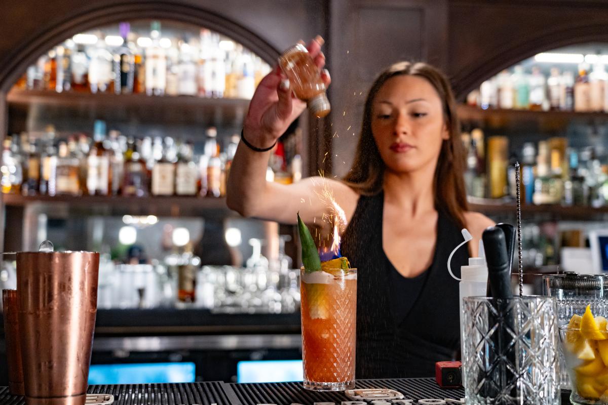 a bartender spicing up a cocktail at the cavern club speakeasy