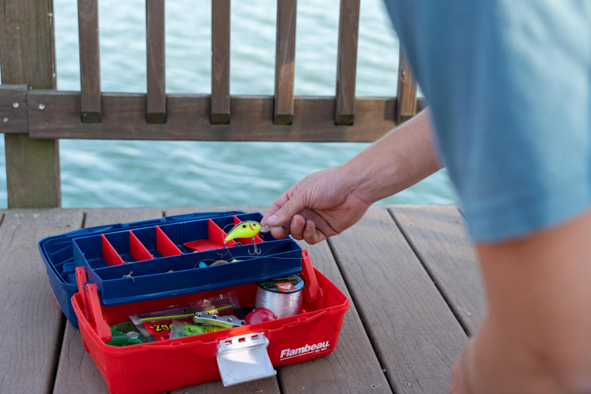 a person taking a lure out of a tackle box