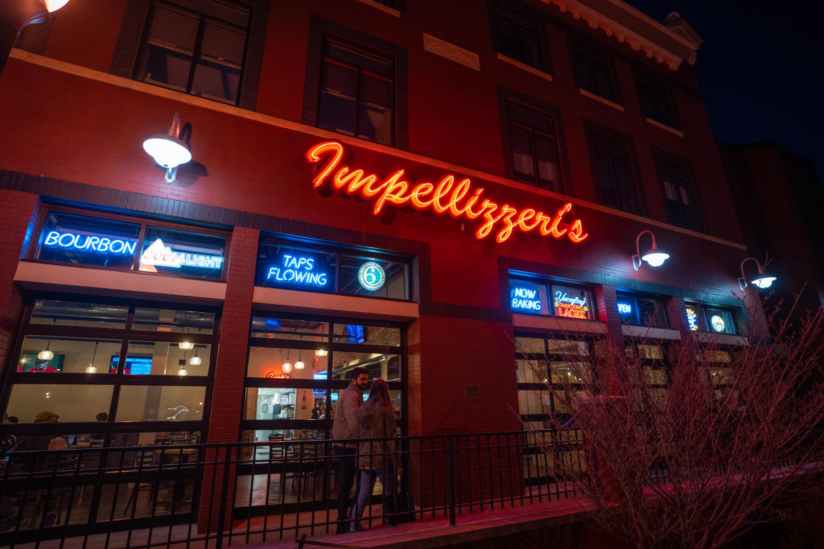 a couple entering impellizzeris in downtown etown at night