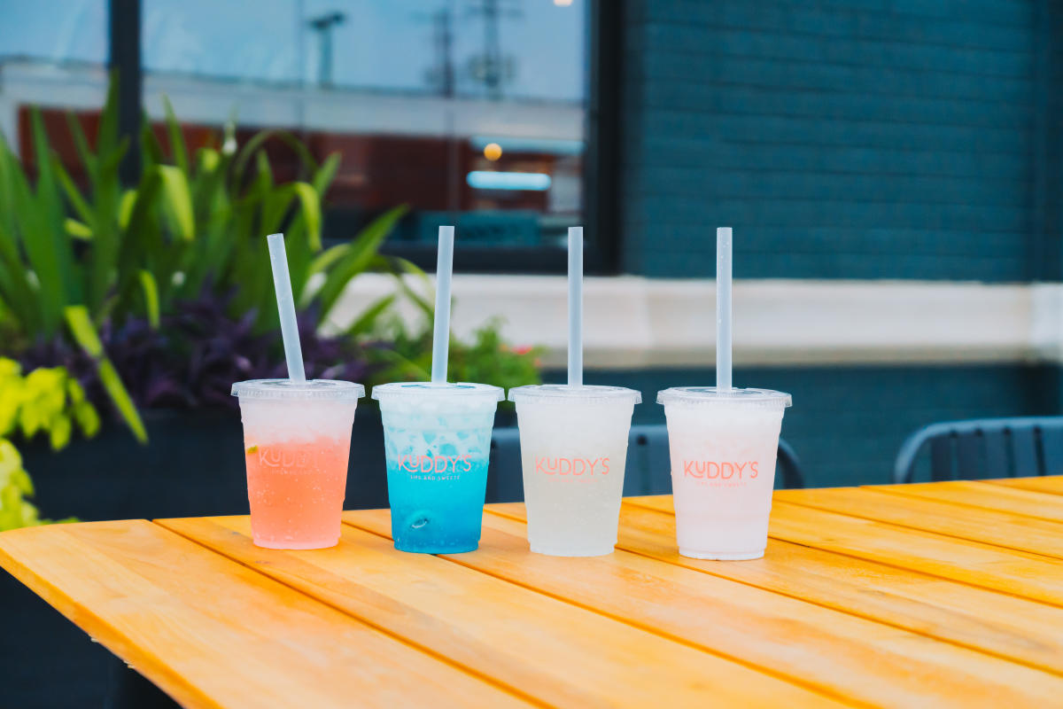 Four drinks sitting on top of a table at Kuddy's in Downtown Elizabethtown, from left to right there is a pink drink, blue drink, and two light white colored drinks.