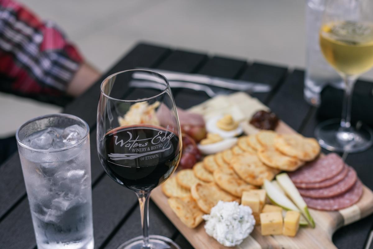 wine and charcuterie on a patio table at waters edge winery